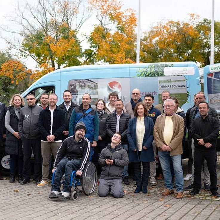 Tatenwerk (St. Josefs-Stift Eisingen gGmbH) folierter gesponsorter Ford Transit fahrerseitig mit Team davor