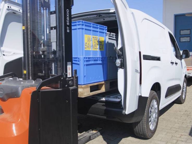 Der heckseitig geöffnete Toyota Proace wird per Gabelstapler mit Ladung auf einer Palette beladen